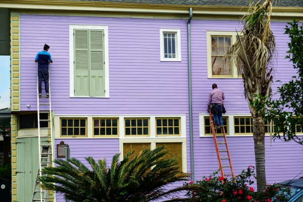 people painting a house purple